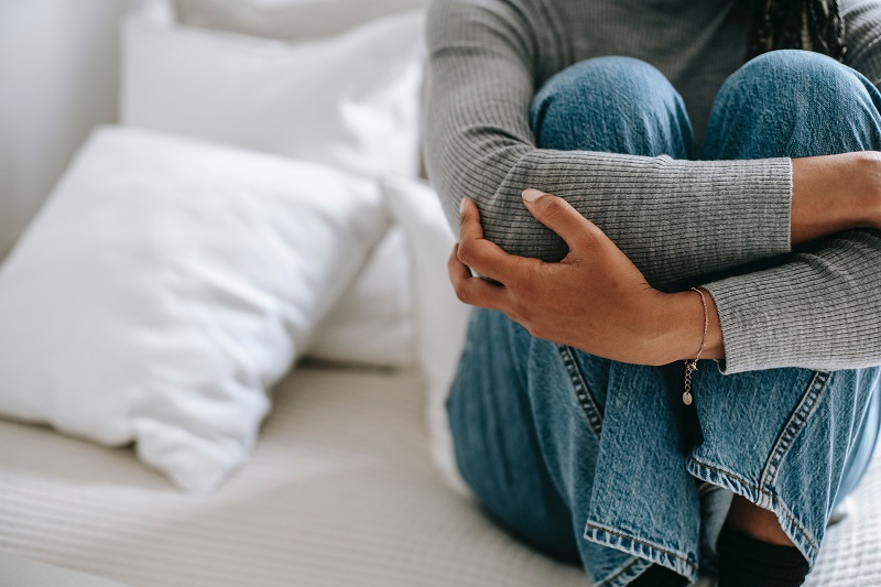 mulher sentada com braços cruzados nas pernas